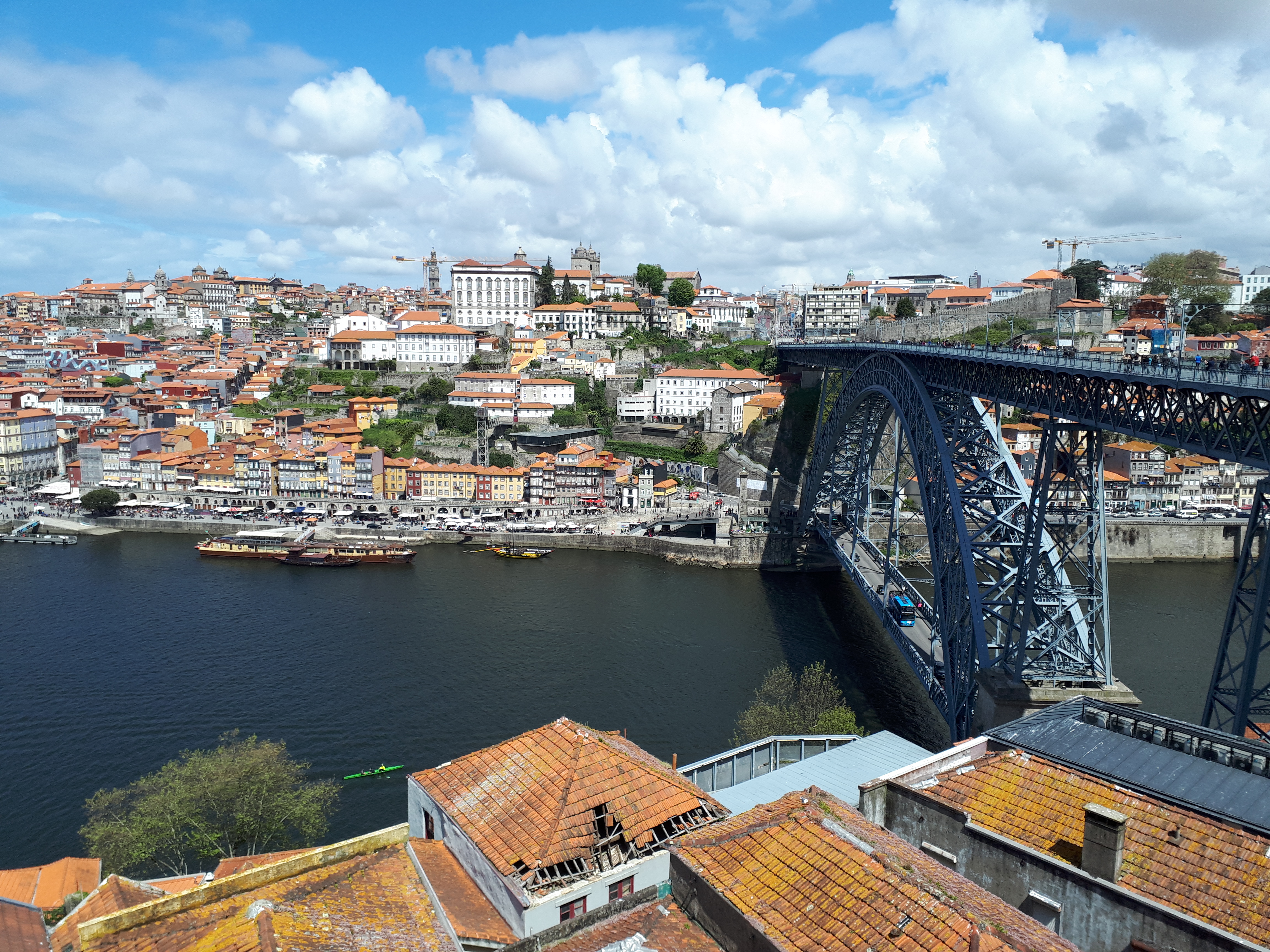 Precioso puente de acero que atraviesa el río Duero con la ciudad de Oporto de fondo y sus tejados anaranjados.