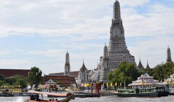 Barca tradicional en el Río Phraya con la imagen del templo Wat Arun detrás.