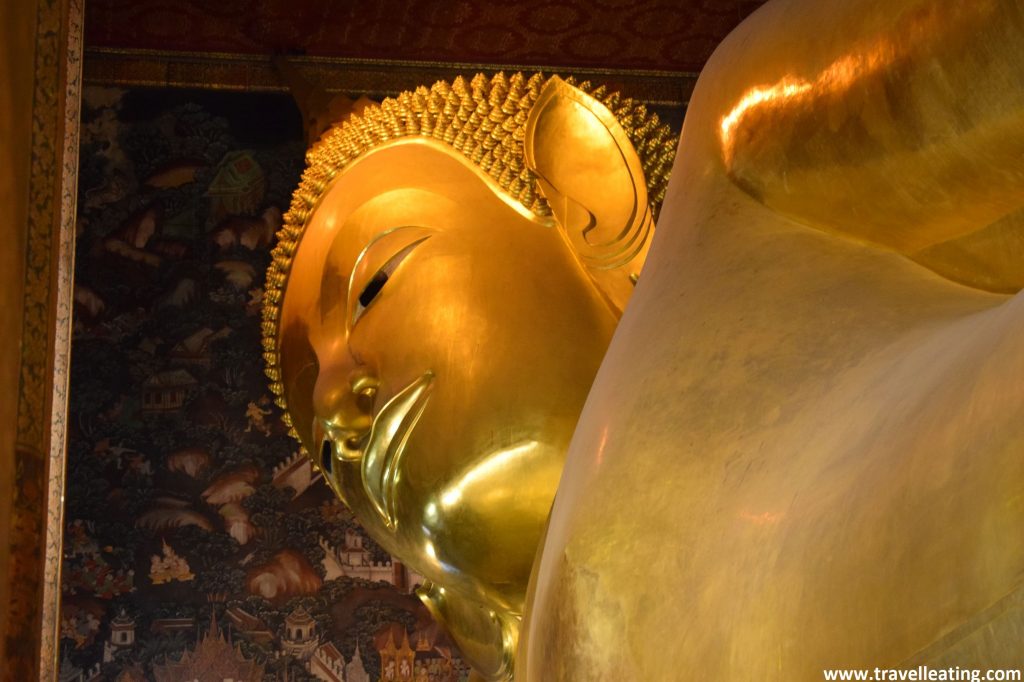 Primer plano de la cara del gran buda reclinado y dorado del Wat Pho, uno de los imprescindibles de Bangkok.