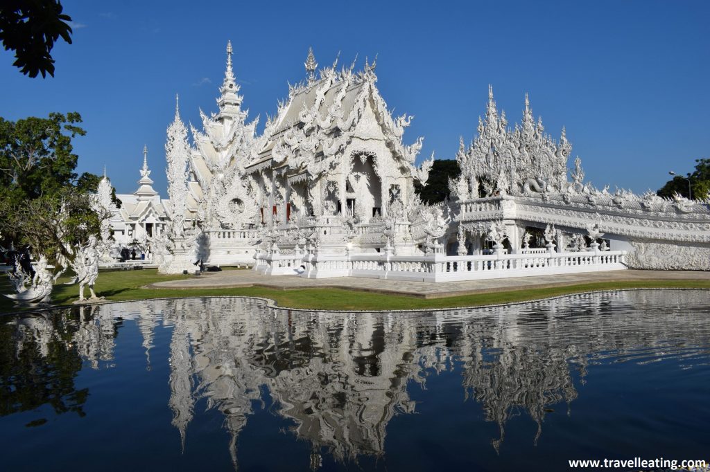 Impresionante templo blanco situado frente a un pequeño estanque en el cual se refleja su imagen.