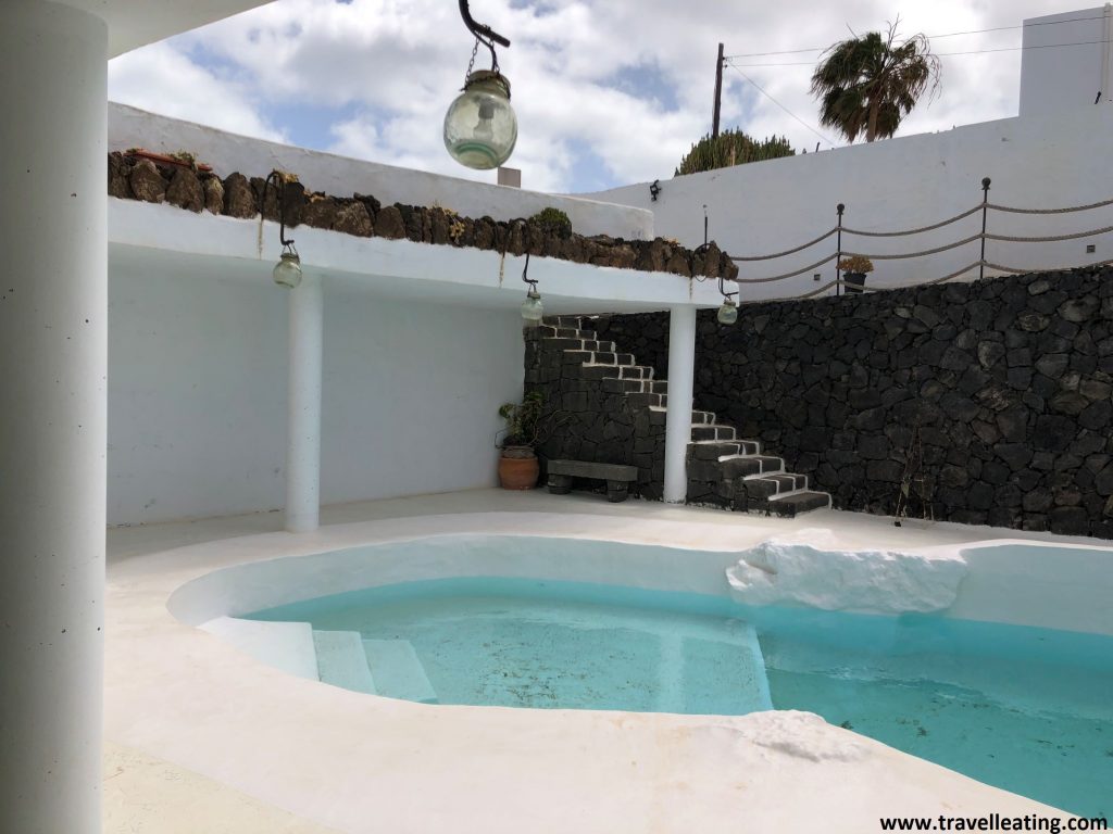 Preciosa piscina de agua turquesa, sobre un suelo blanco impoluto, de uno de los mejores lugares donde alojarse en Lanzarote