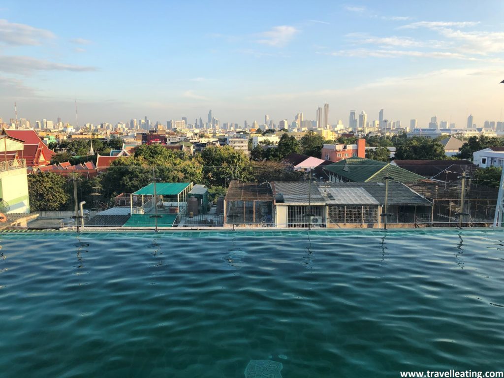 Piscina infinita con vistas a la ciudad de Bangkok al atardecer.