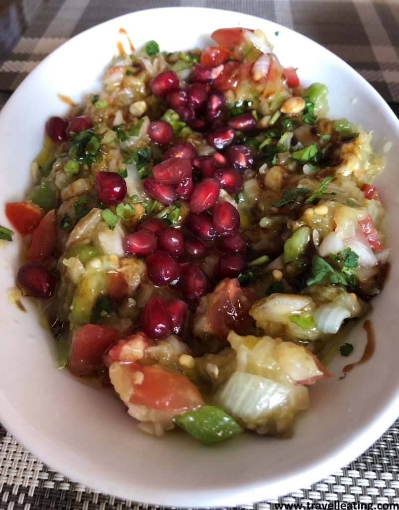 Plato de baba ganoush, este puré de berenjenas con trozos de tomate y cebolla, servido con granada por encima y especies aromáticas.