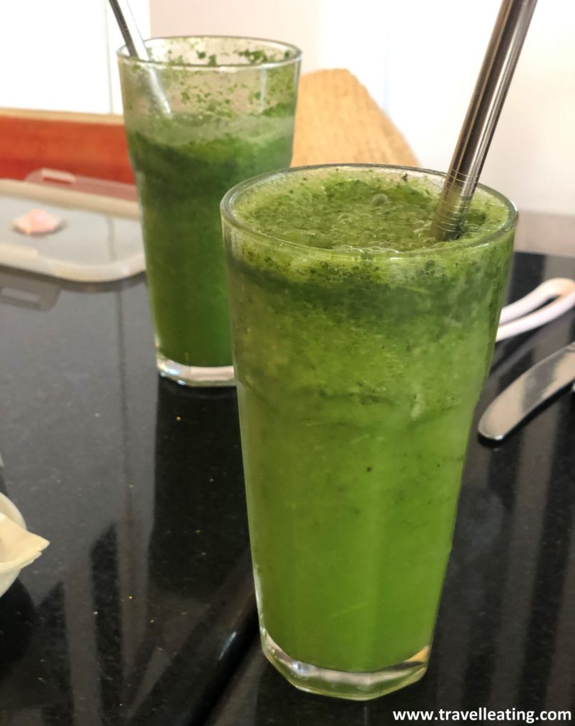Dos vasos de limonada verde por la menta, que tienen una pajita de acero cada una de ellas.