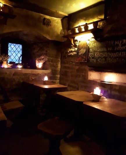 Precioso comedor con las paredes de piedra e iluminado por velas, al más puro estilo medieval.