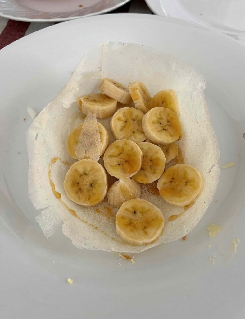 Egg Hoppers con plátano y sirope en un desayuno típico de Sri Lanka.