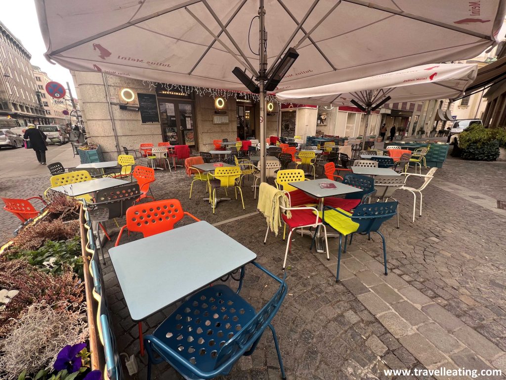 Terraza repleta de sillas coloridas del Café Korb, una cafetería histórica de Viena.