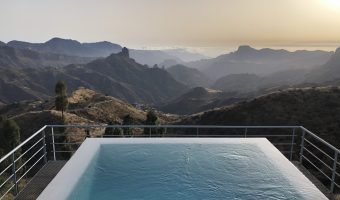 Atardecer visto desde una piscina infinita que tiene unas preciosas vistas a las montañas. Se trata de la piscina de uno de los hoteles más recomendados en Gran Canaria.