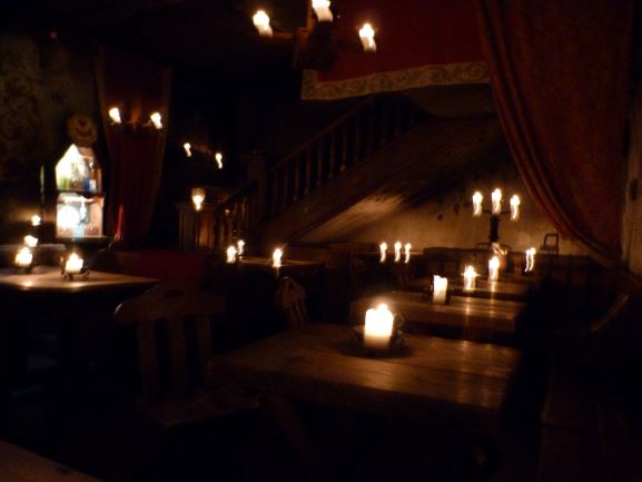 Interior de un restaurante de estilo medieval decorado con velas y antorchas. Uno de los restaurantes imprescindibles de visitar y ver en Tallin.